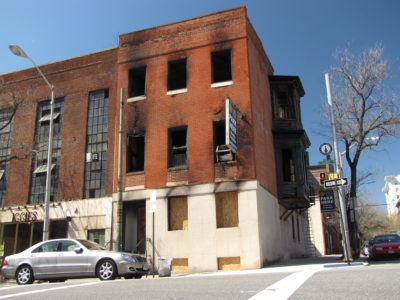 East facade, facing north Calvert Street.  The first floor windows, which contained the smoking lounge and the offices for the National Coalition for Sexual Freedom, are boarded up.  The windows for the dungeon spaces are broken out and open.